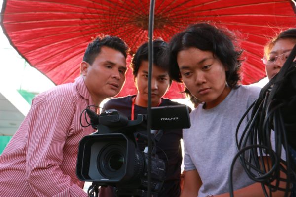 Opiskelijoita Myanmarissa kameran kanssa