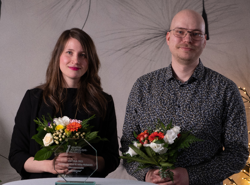 Karoliina Knuuti ja Mika Niskanen hymyilevät kukkakimput kädessään