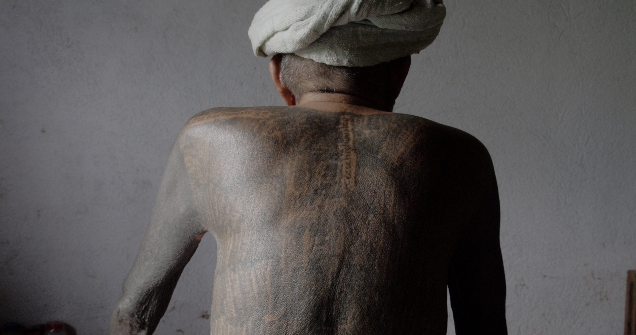 Mies istuu selin kameraan