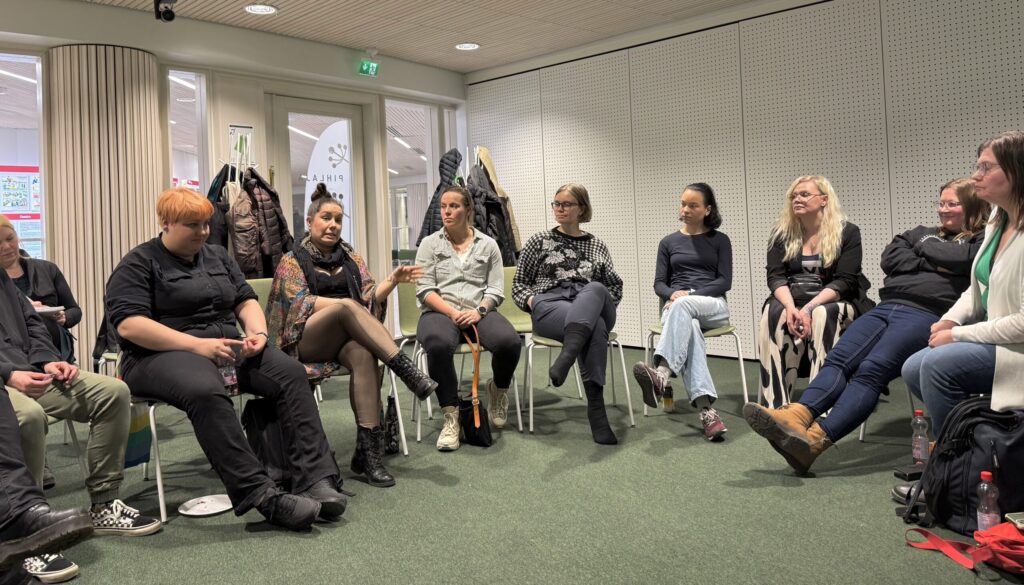 Ihmiset istuvat dialogipiirissä kirjaston huoneessa.